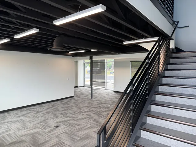 Modern commercial interior featuring an open-concept layout with large windows