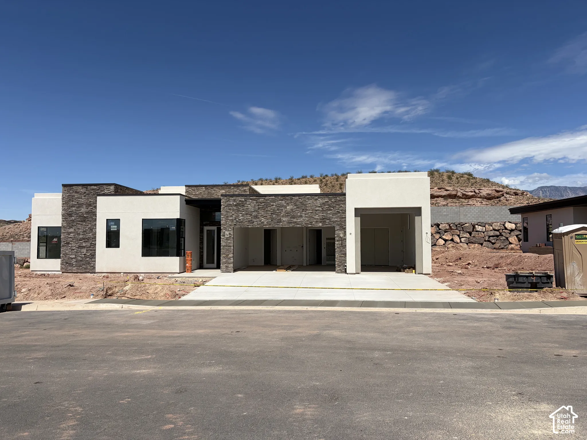Contemporary exterior with stone accent siding, clean stucco finishes, and an integrated two-car garage