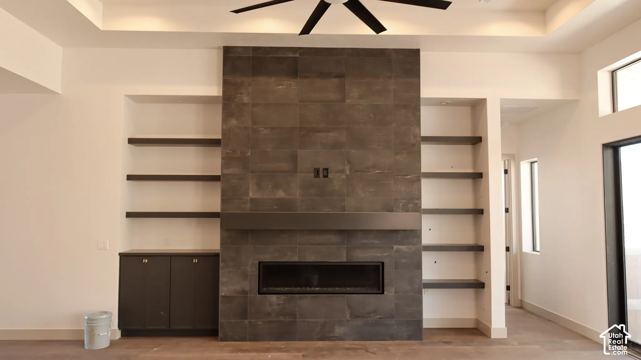 Contemporary fireplace wall featuring a linear electric fireplace, stone-finish tile surround, and an integrated mantel