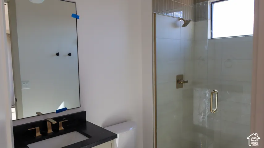 Single vanity with a dark countertop and gold-toned faucet