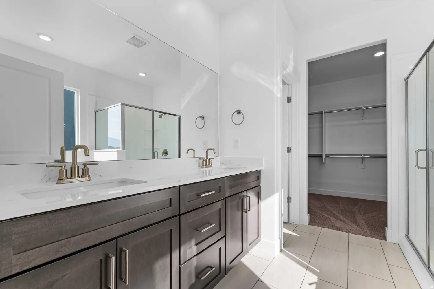 Dual vanity with integrated sinks and brushed nickel faucets, set against a full-width mirror