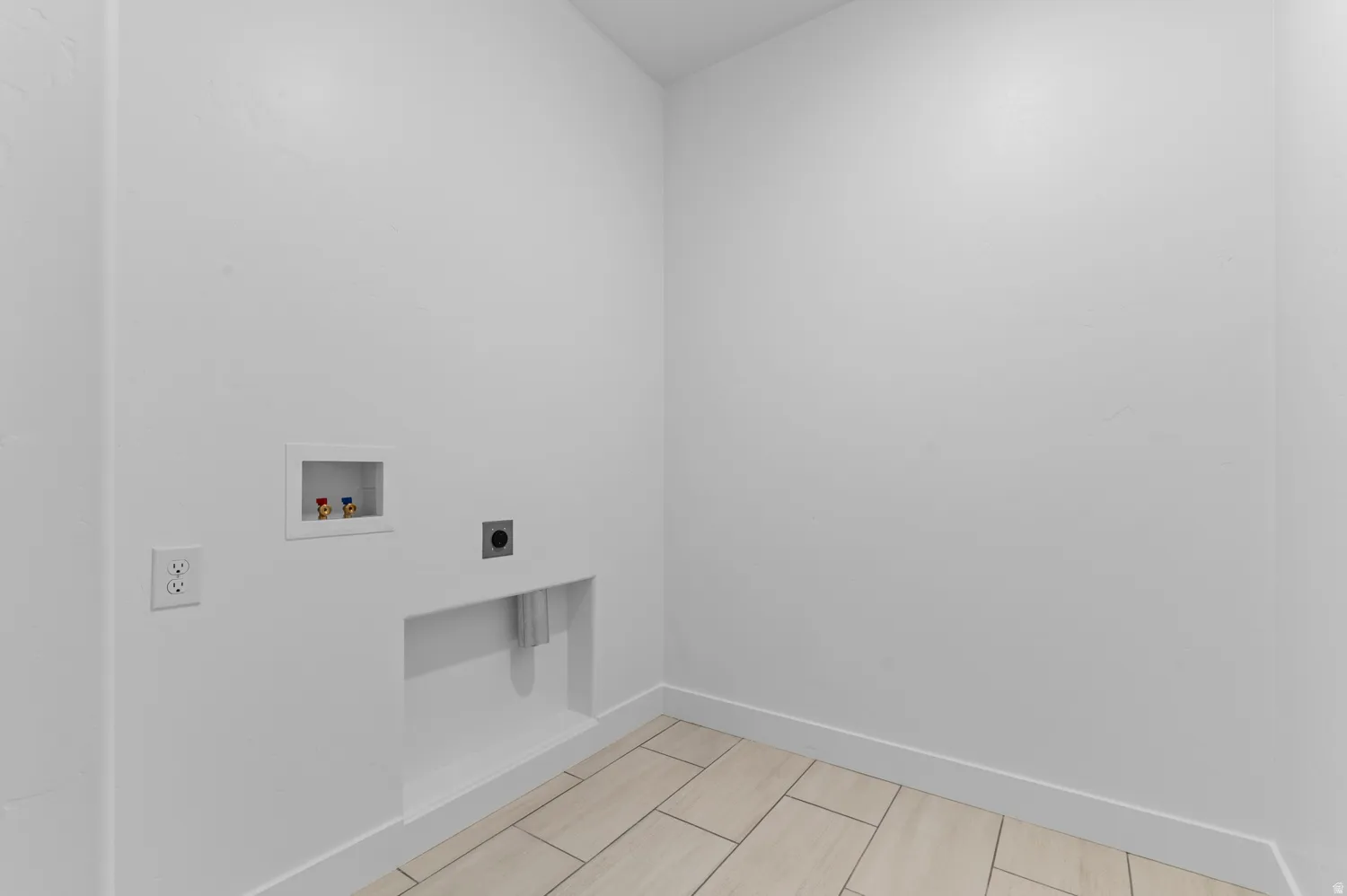 Dedicated laundry area featuring light wood-finish tile flooring and bright white walls