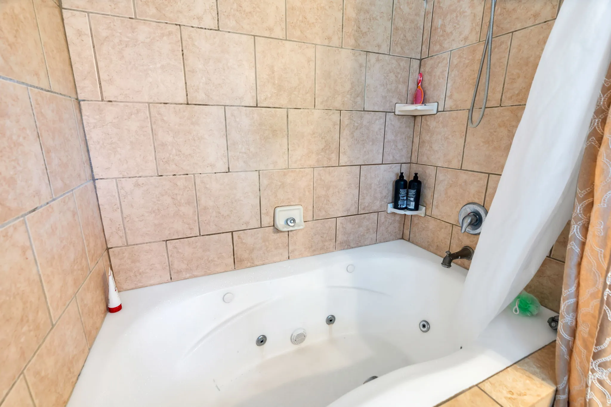 Tiled shower and tub surround featuring a built-in jetted tub