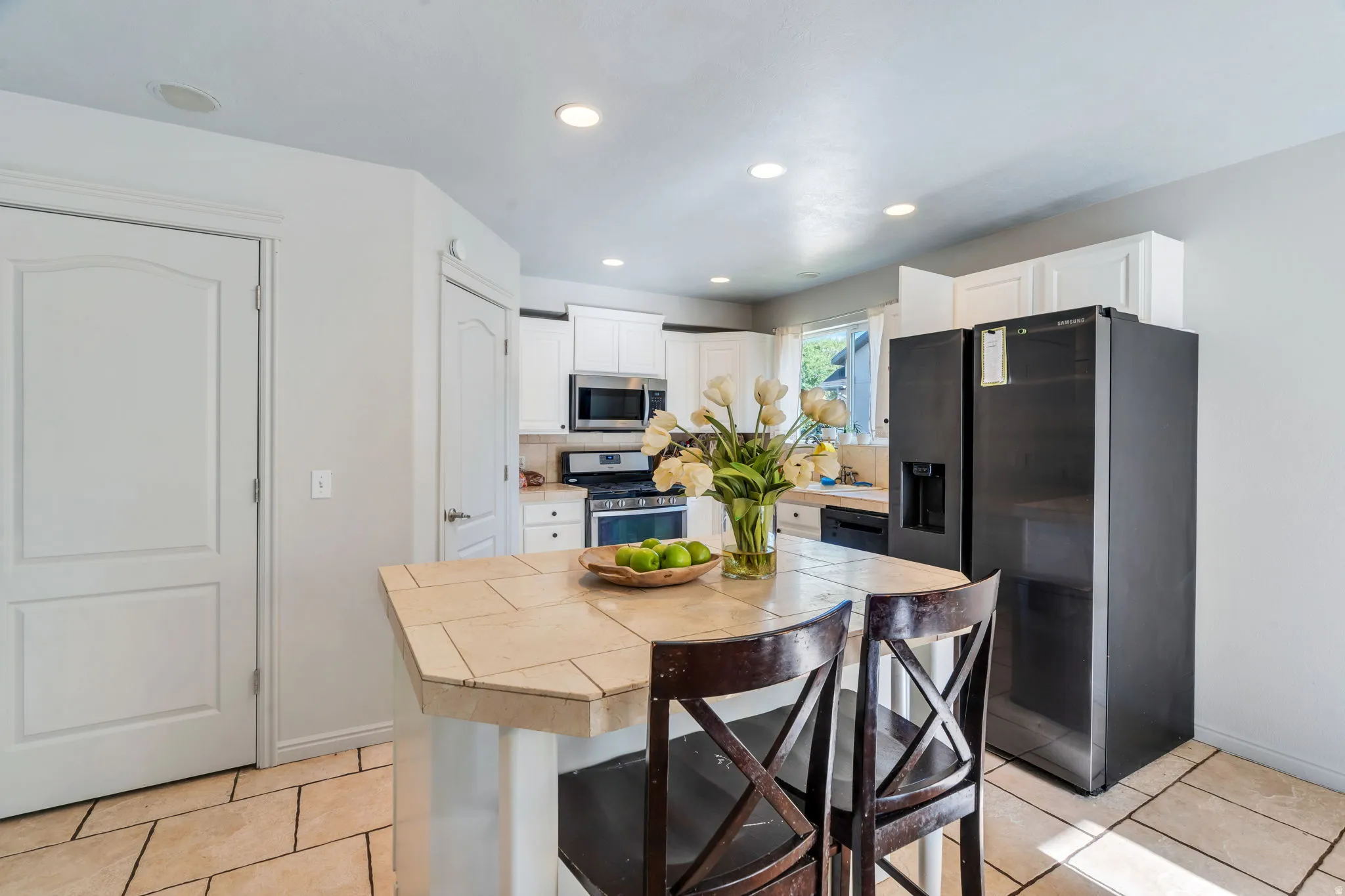 Kitchen featuring a tile island, integrated sink, and stainless steel appliances