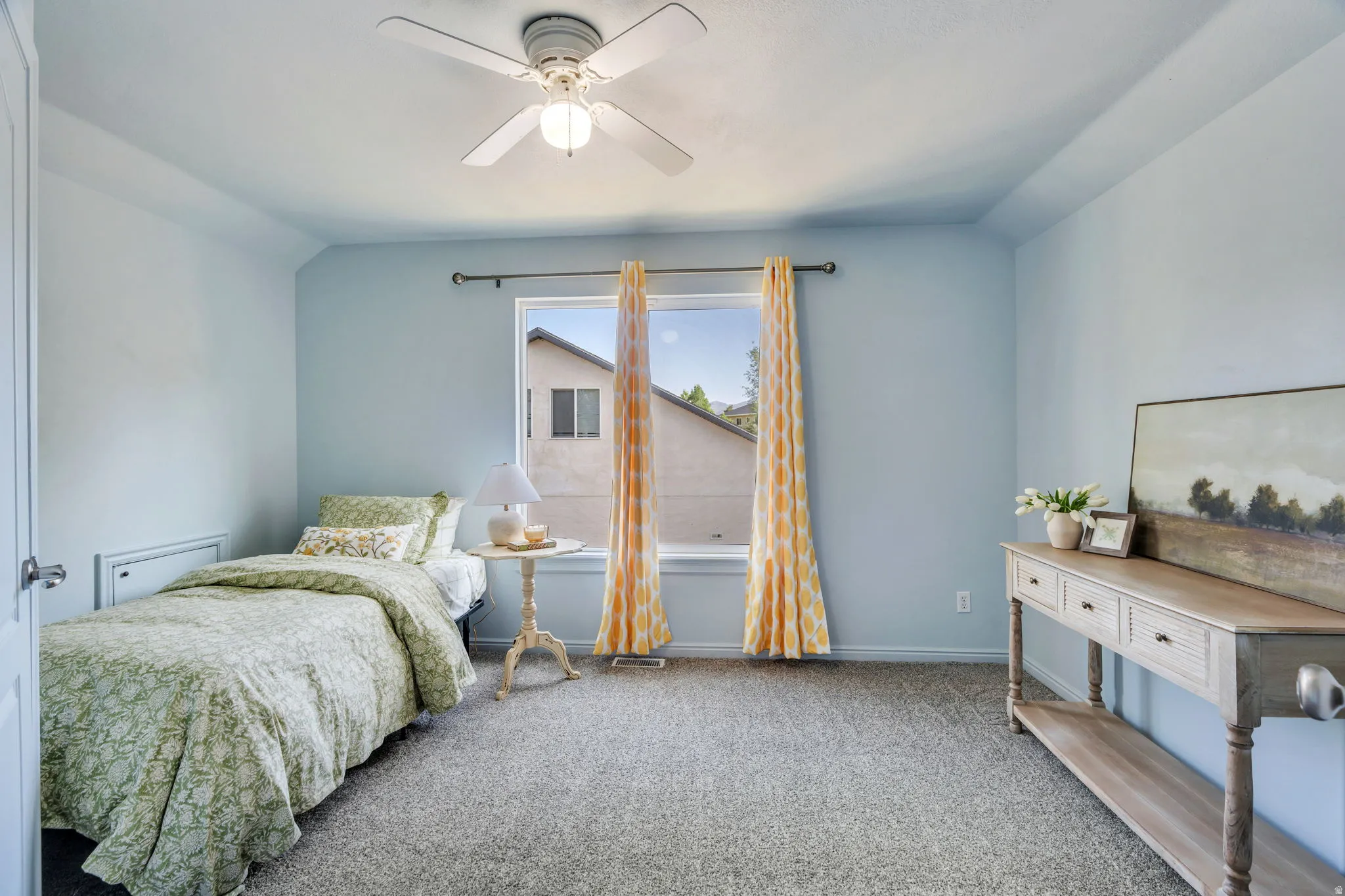 Carpeted room featuring a ceiling fan with integrated lighting, a window with a curtain rod, and light blue wall tones