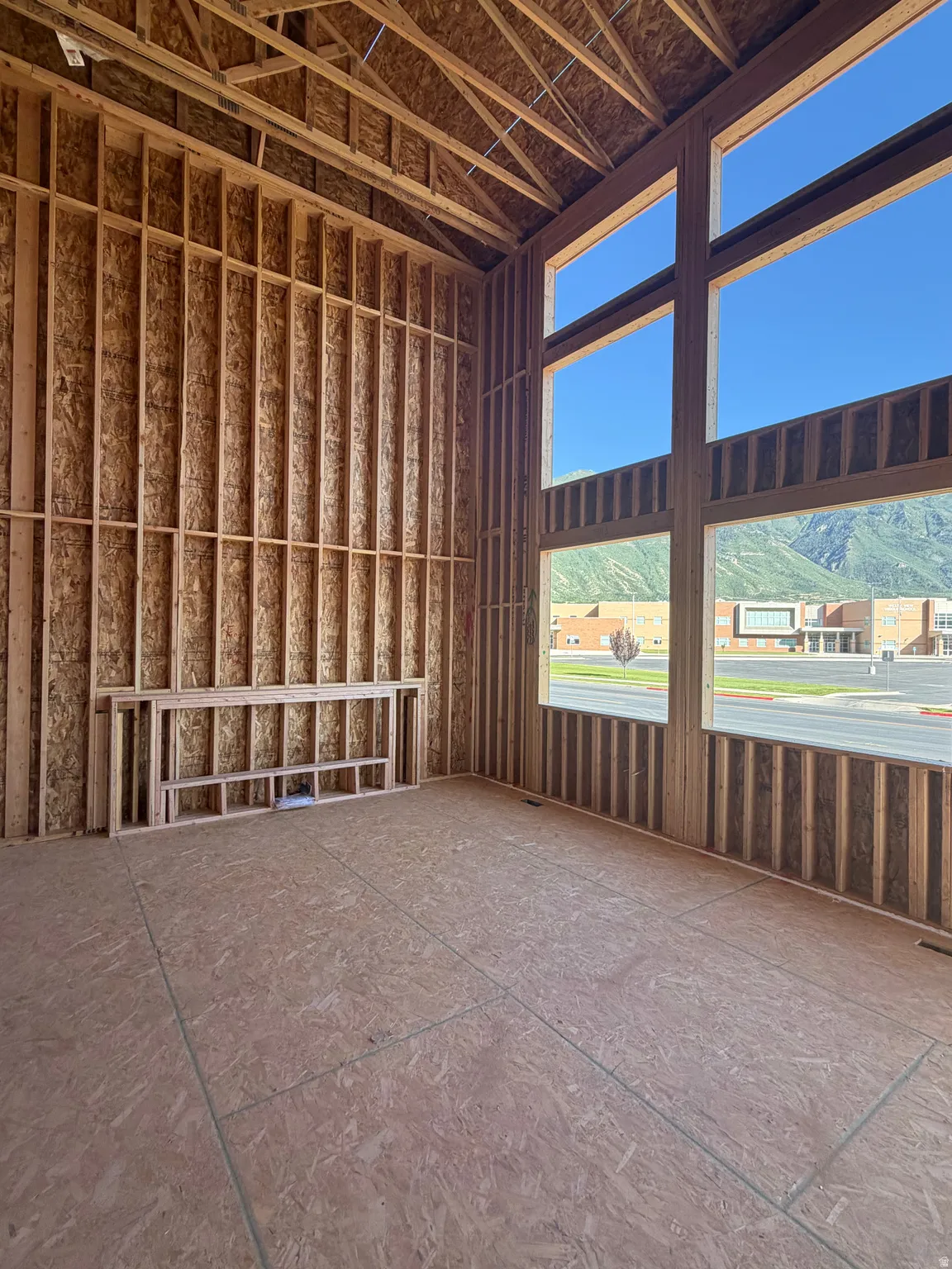 Spacious room featuring substantial wall framing and an exposed ceiling