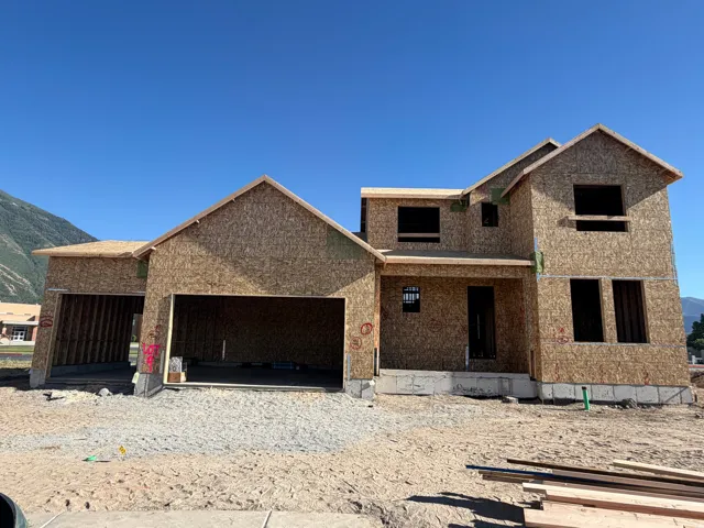 New construction residential structure featuring an attached multi-car garage, multiple gabled rooflines, and a covered entry