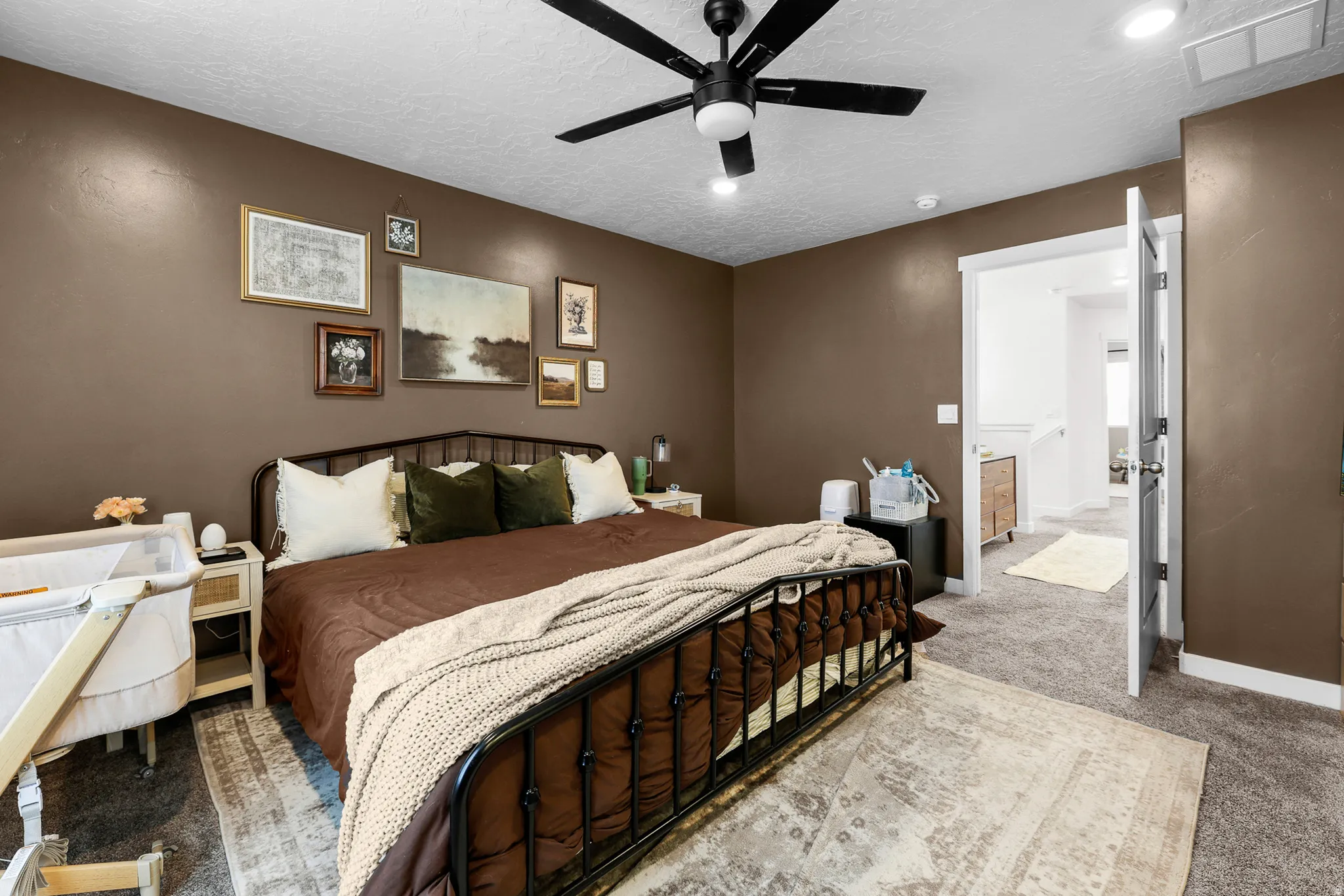 Spacious bedroom featuring brown walls, recessed lighting, and a ceiling fan
