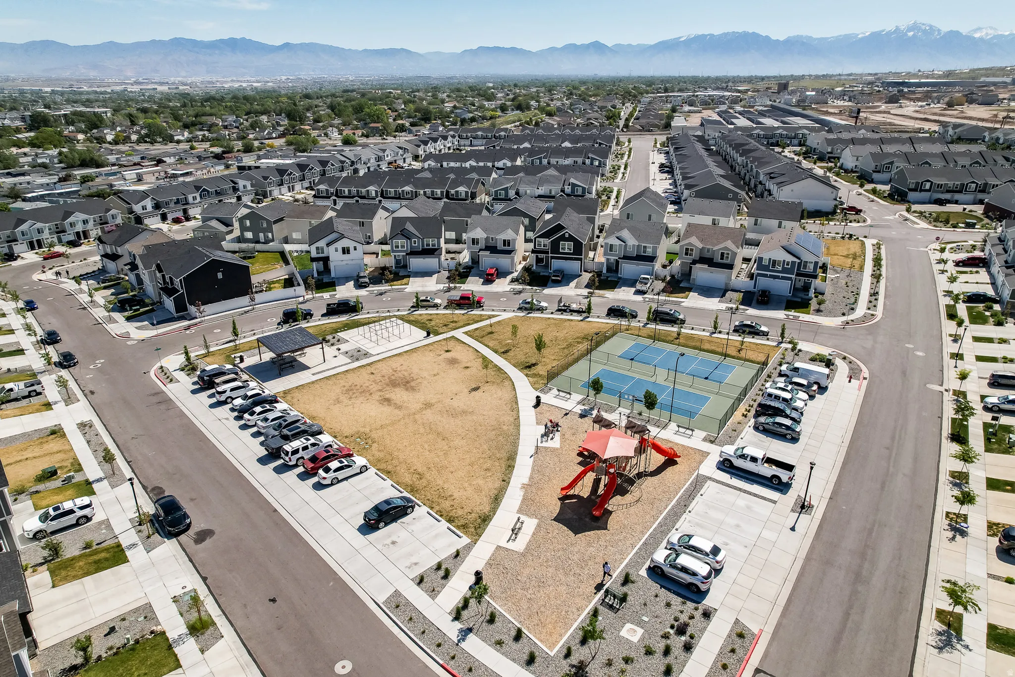 Community park featuring a playground, tennis courts, and open green space