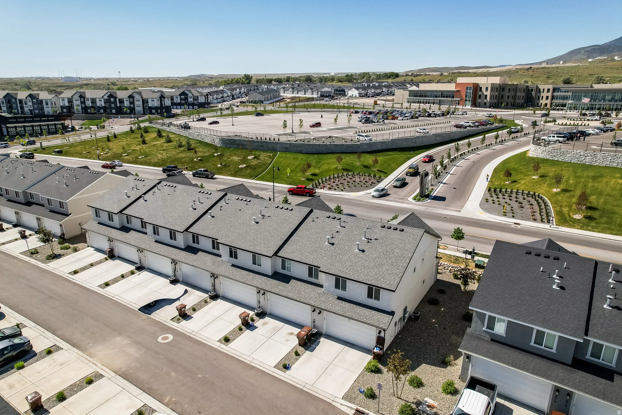 Modern townhome community featuring multi-level residences with attached garages and paved driveways
