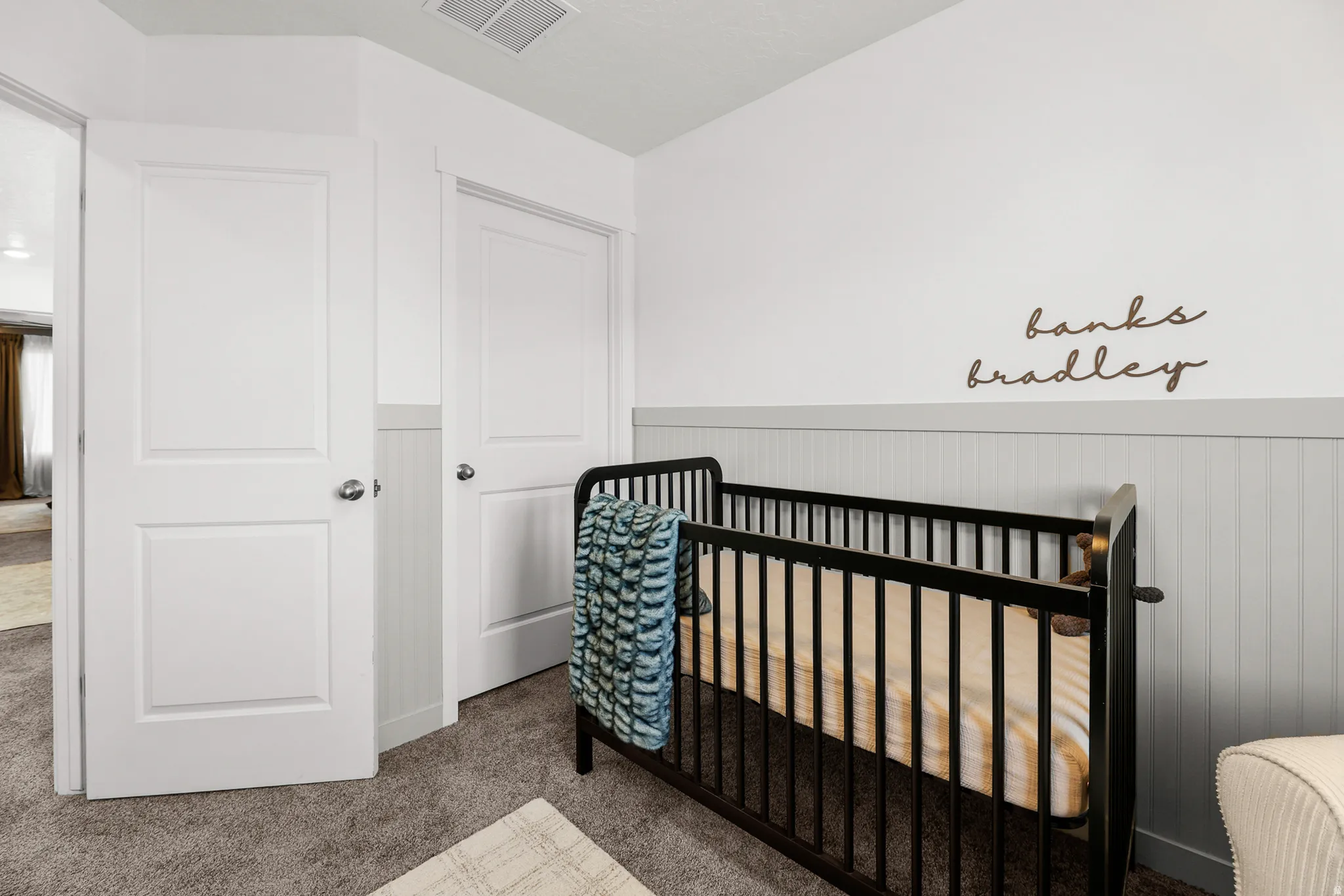 Room featuring soft grey wall paneling and a contrasting white upper wall