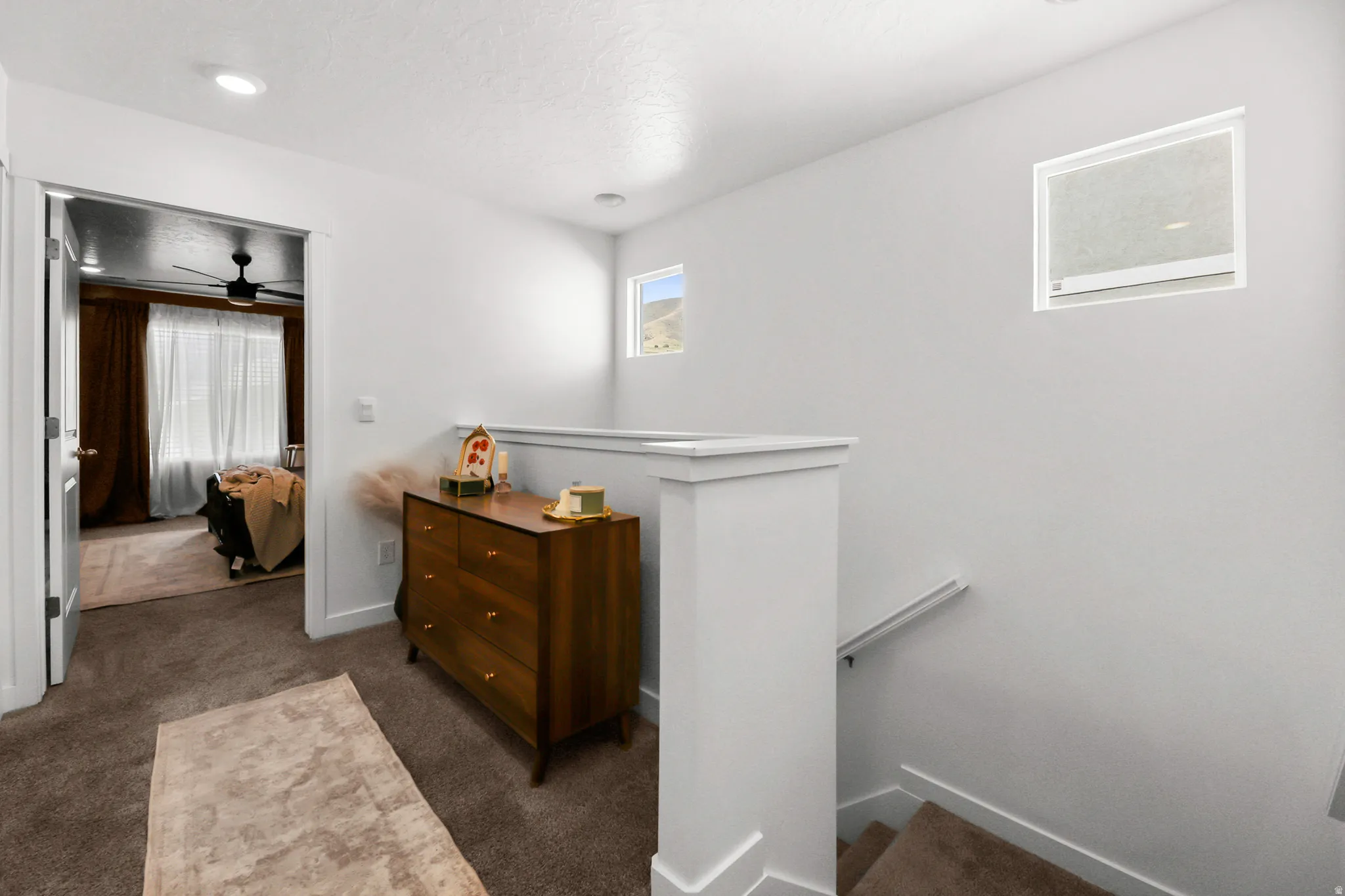 Upper-level landing featuring neutral carpet flooring and white walls