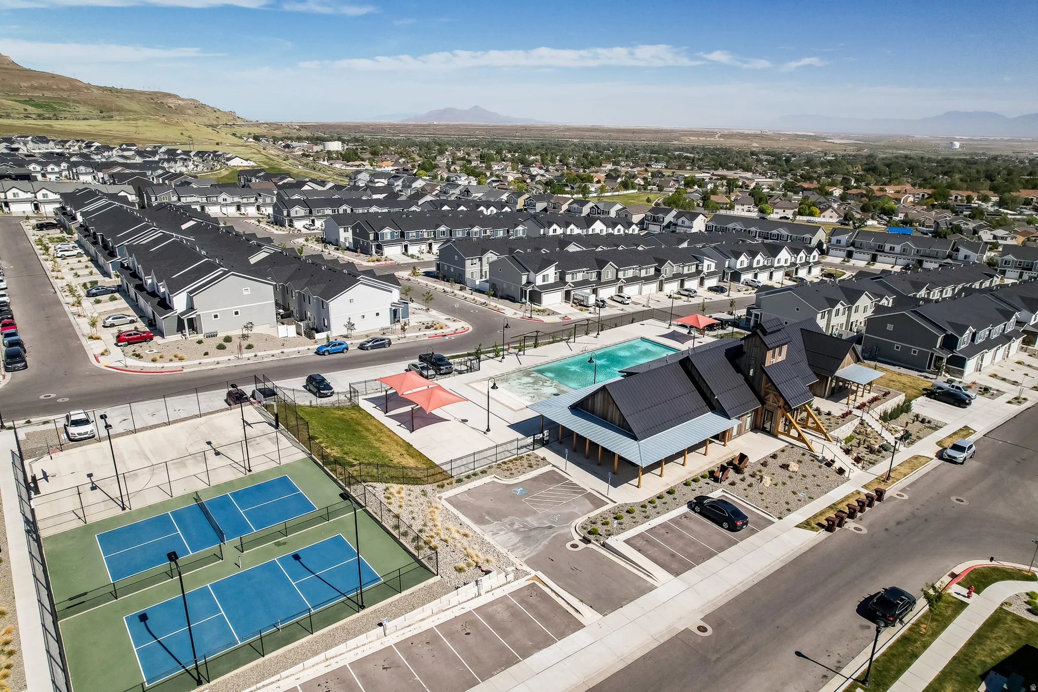 Community amenities featuring two pickleball courts, an outdoor swimming pool, and a clubhouse with a covered patio