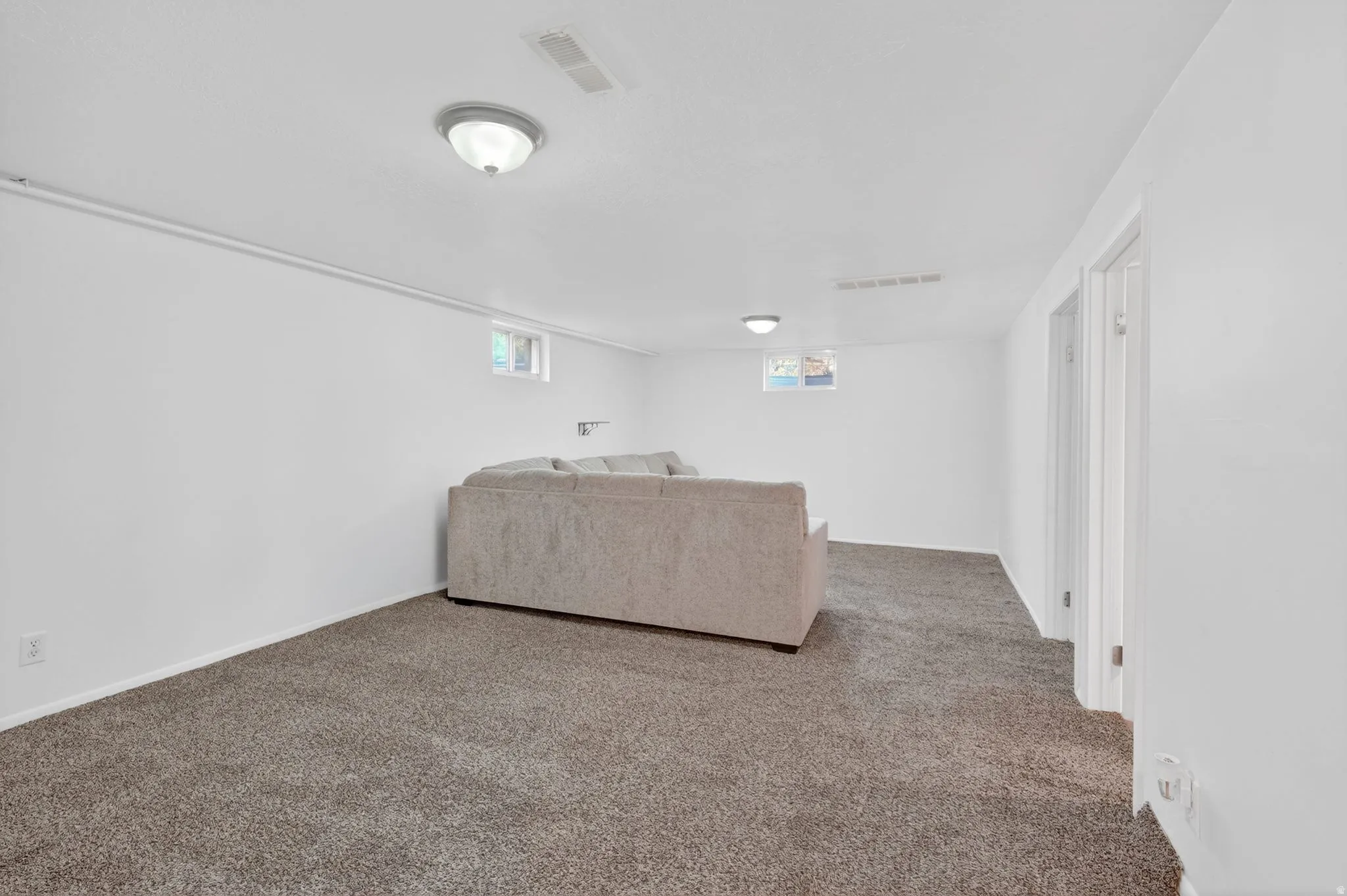 Spacious room featuring neutral carpeting and white walls