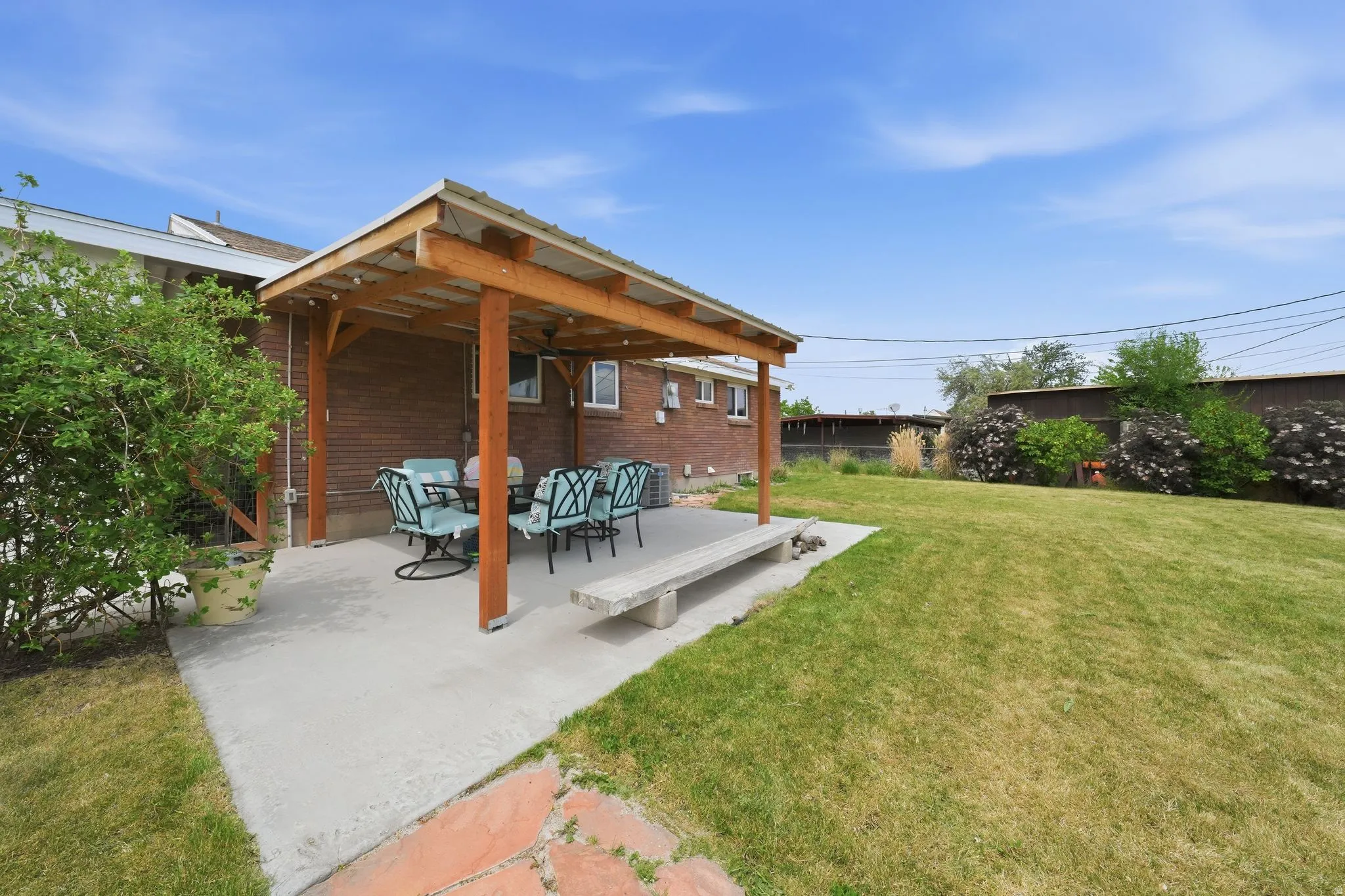 Expansive backyard featuring a wood pergola over a concrete patio