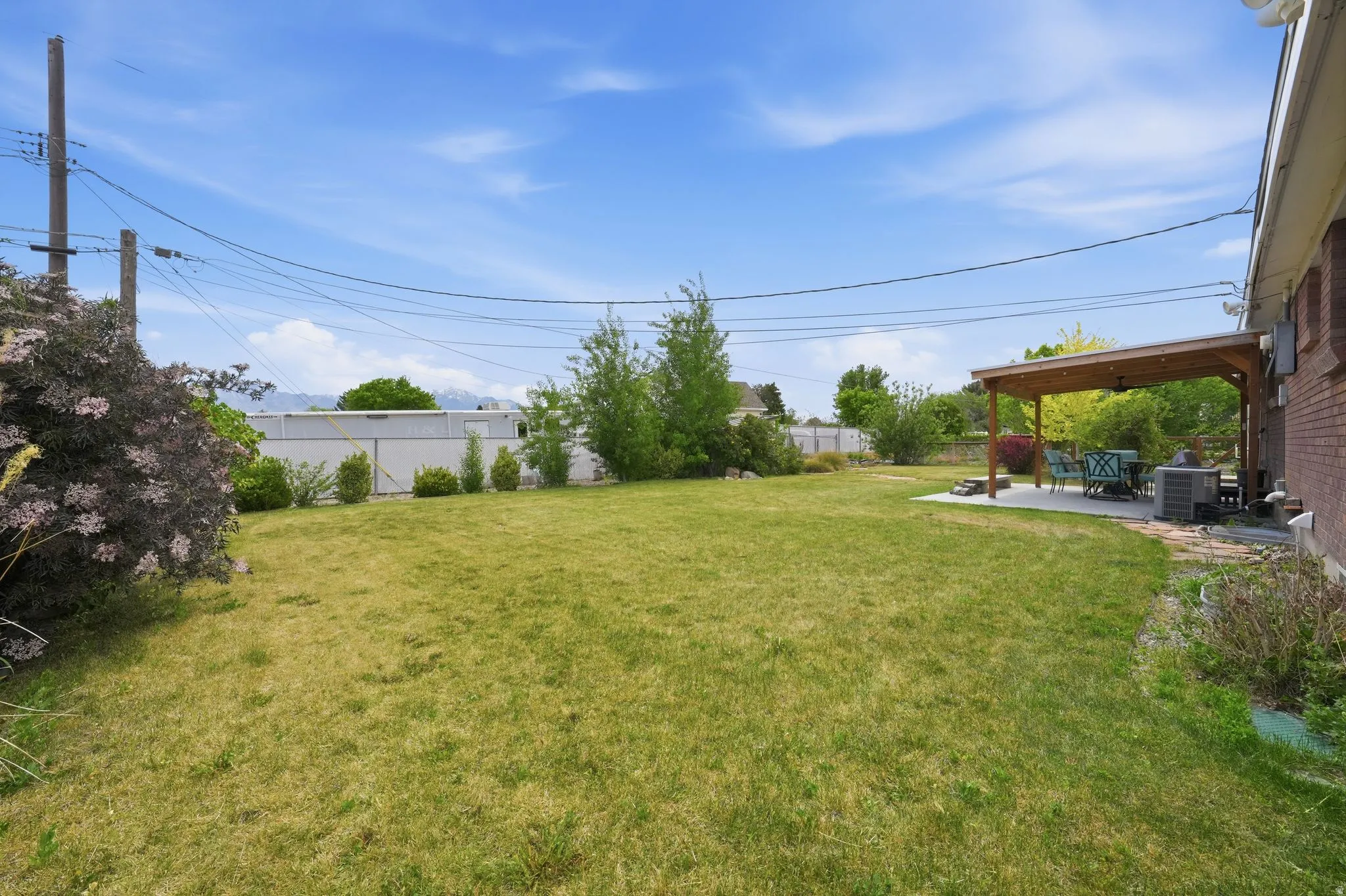 Expansive green lawn with a covered patio area