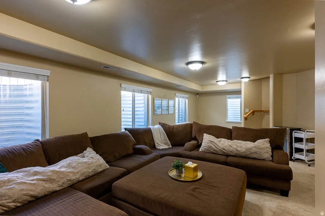 Spacious finished basement offering recessed lighting, multiple windows, light beige wall paint, and beige carpet flooring