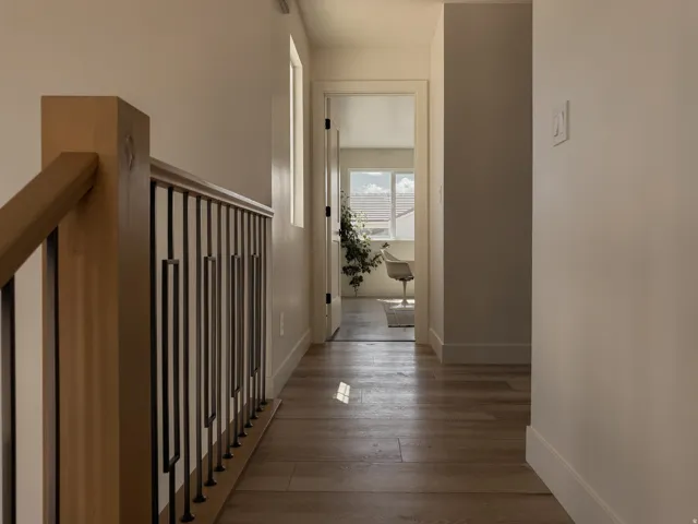 Hallway with wood-finish flooring and light-toned walls
