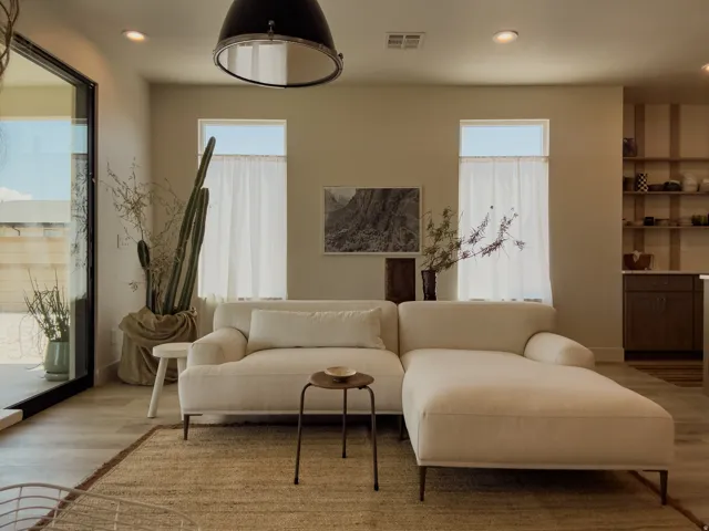 Expansive sliding glass door, recessed lighting, wood-finish flooring, two large windows with valances, and open shelving