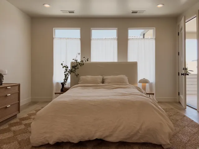 Bedroom featuring three transom windows with privacy curtains, recessed lighting, wood-finish flooring, and a French door opening to an exterior space