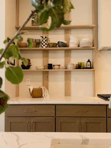 Kitchen featuring open wood shelving with wood-finish base cabinetry and white countertops