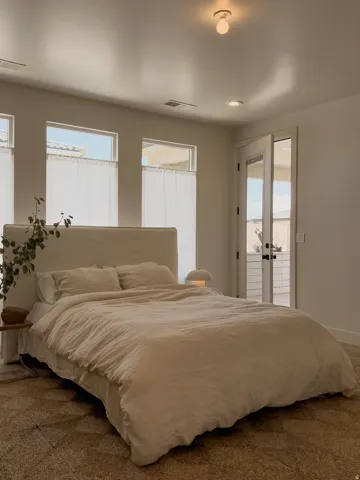 Spacious room featuring multiple transom windows, a double French door with dark hardware, recessed lighting, and a textured floor covering