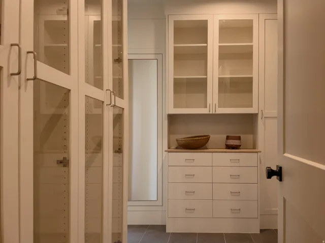 Built-in custom cabinetry featuring glass-front doors, adjustable shelving, and integrated drawer storage