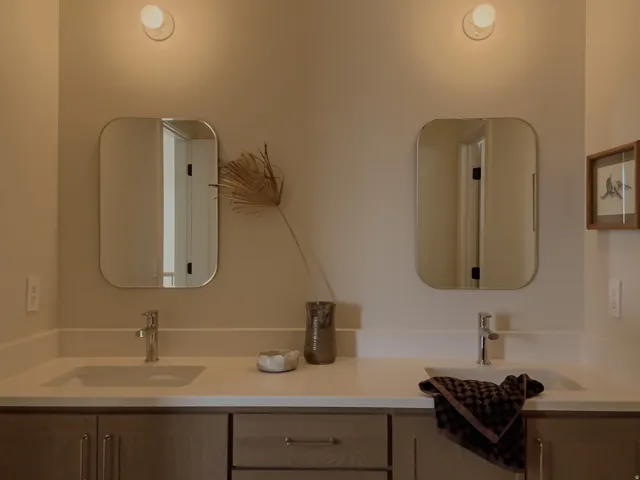 Dual vanity with integrated sinks, light-toned countertop, and chrome fixtures