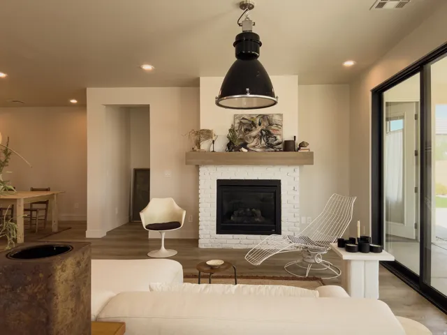 Living area featuring a white brick fireplace with a wood mantle, recessed lighting, and wood-finish flooring