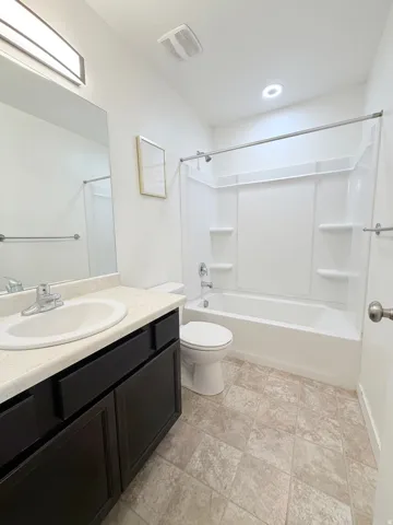 Bathroom 2 top floor-  featuring a dark wood-finish vanity, integrated sink with chrome faucet, a full-width mirror, and overhead linear lighting
