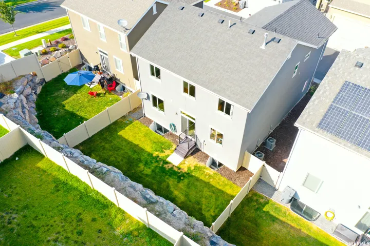 Backyard- exterior of a two-story residence featuring a gray facade and a gray shingle roof