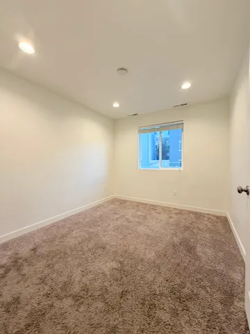 Carpeted interior space featuring white walls and recessed ceiling lighting and closet