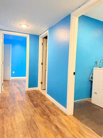 Hallway featuring wood-finish flooring, recessed lighting, and white trim