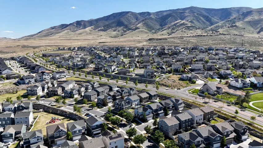 Extensive residential development featuring numerous single-family homes, integrated streets, and a green space with recreational equipment