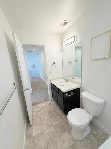 Bathroom 2 top floor featuring a dark wood vanity with a white countertop, an integrated sink, a large wall mirror, and modern overhead lighting