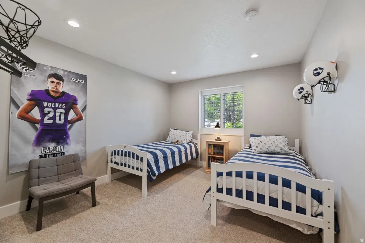 Carpeted room with recessed lighting and a window featuring white horizontal blinds
