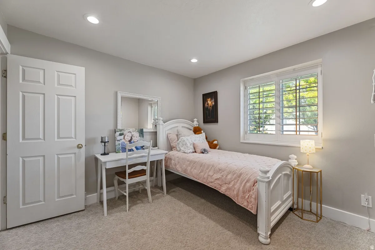 Bedroom featuring plush carpeting, recessed lighting, and a white six-panel door
