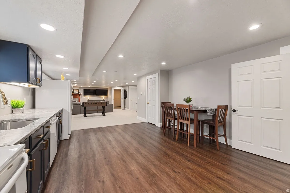 Open-concept lower level featuring wood-finish flooring and recessed lighting