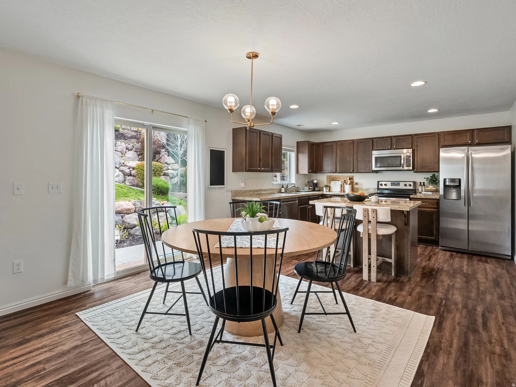 Open-concept dining area featuring a wood-finish floor and a glass sliding door