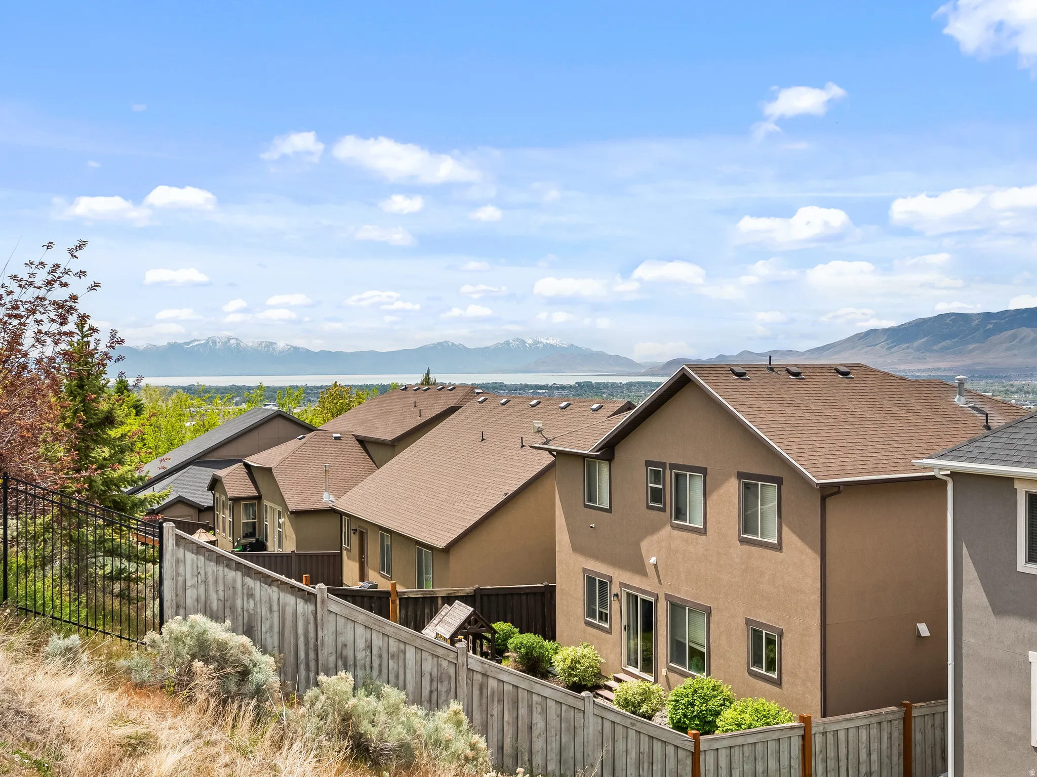 Gorgeous Utah Lake Views. Terraced property featuring a private backyard, wood privacy fencing, and an upper-level patio door