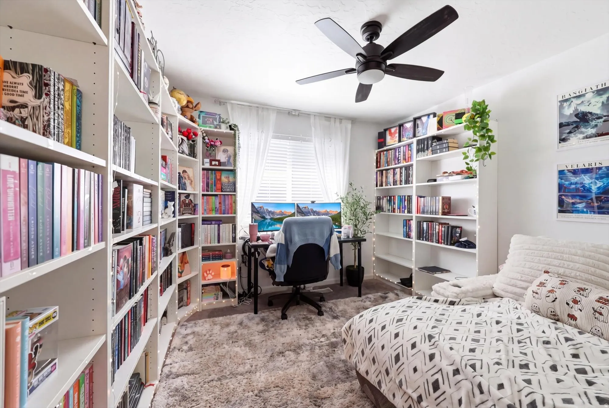 Room with extensive built-in shelving, a ceiling fan, and window with blinds