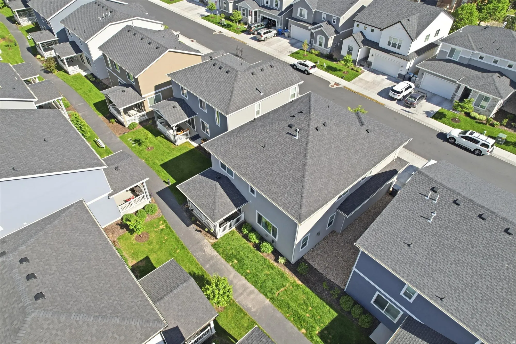 Aerial overview showcasing a residential neighborhood with uniformly designed homes featuring dark gray shingle roofs