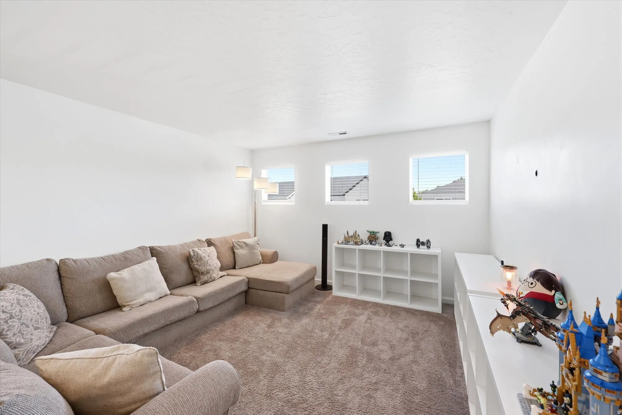 Carpeted and spacious loft area with multiple windows providing natural light