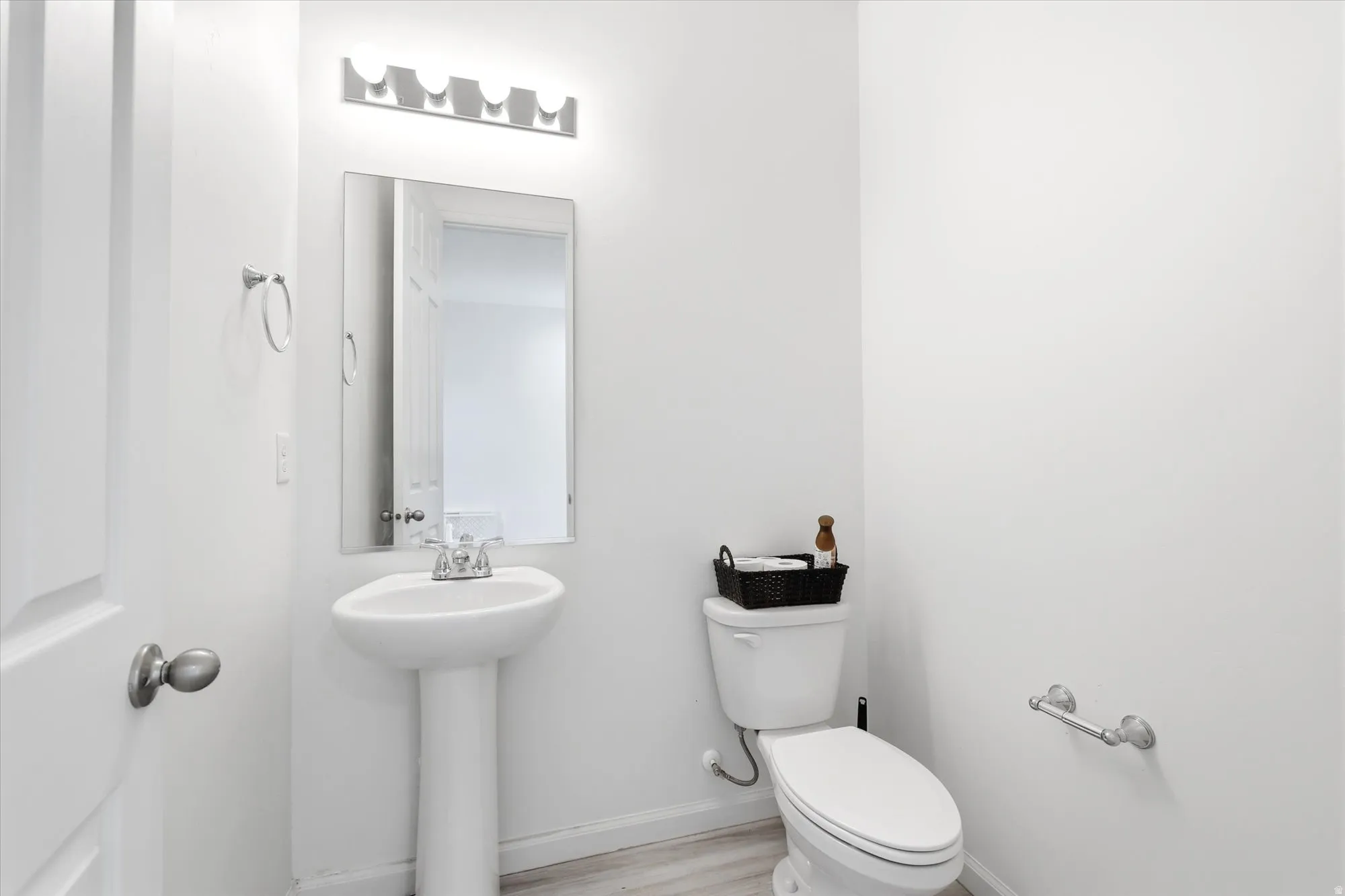 Pedestal sink featuring a chrome faucet and a rectangular wall-mounted mirror