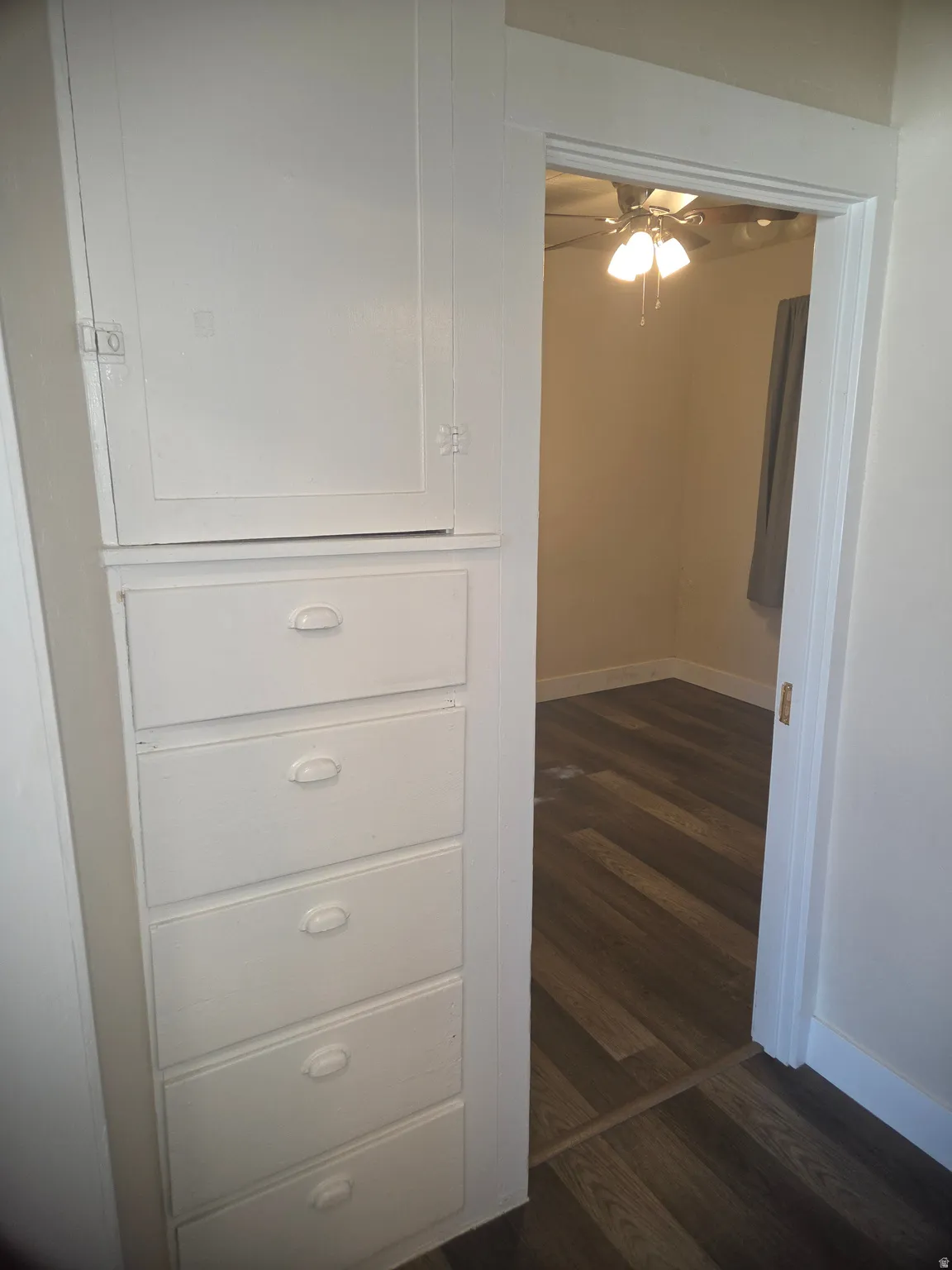 Built-in white cabinetry with five drawers and an upper storage cabinet