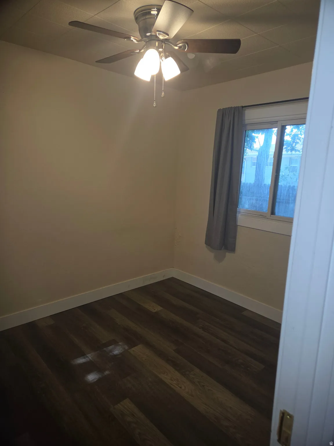 Room featuring wood-finish flooring, light-toned walls, and white baseboards