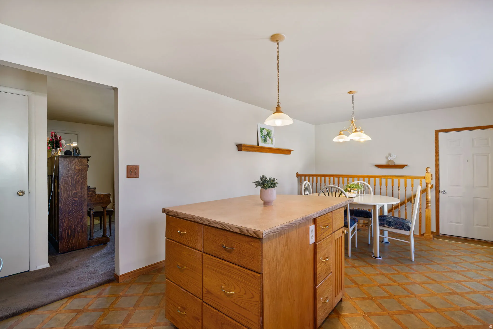Kitchen island with wood-finish cabinetry and a light-toned countertop, complemented by a patterned floor