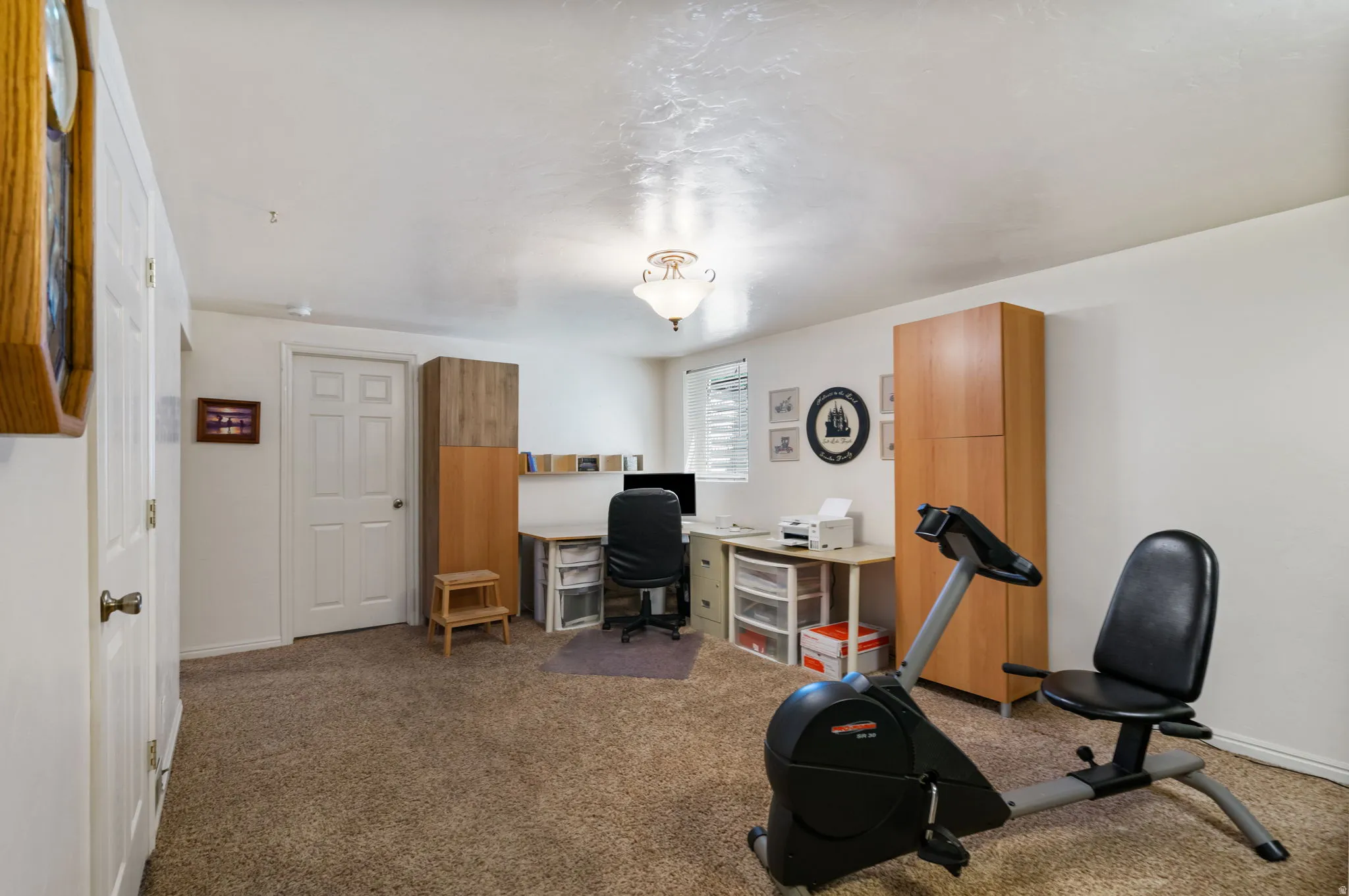Carpeted room with white walls and a white six-panel door
