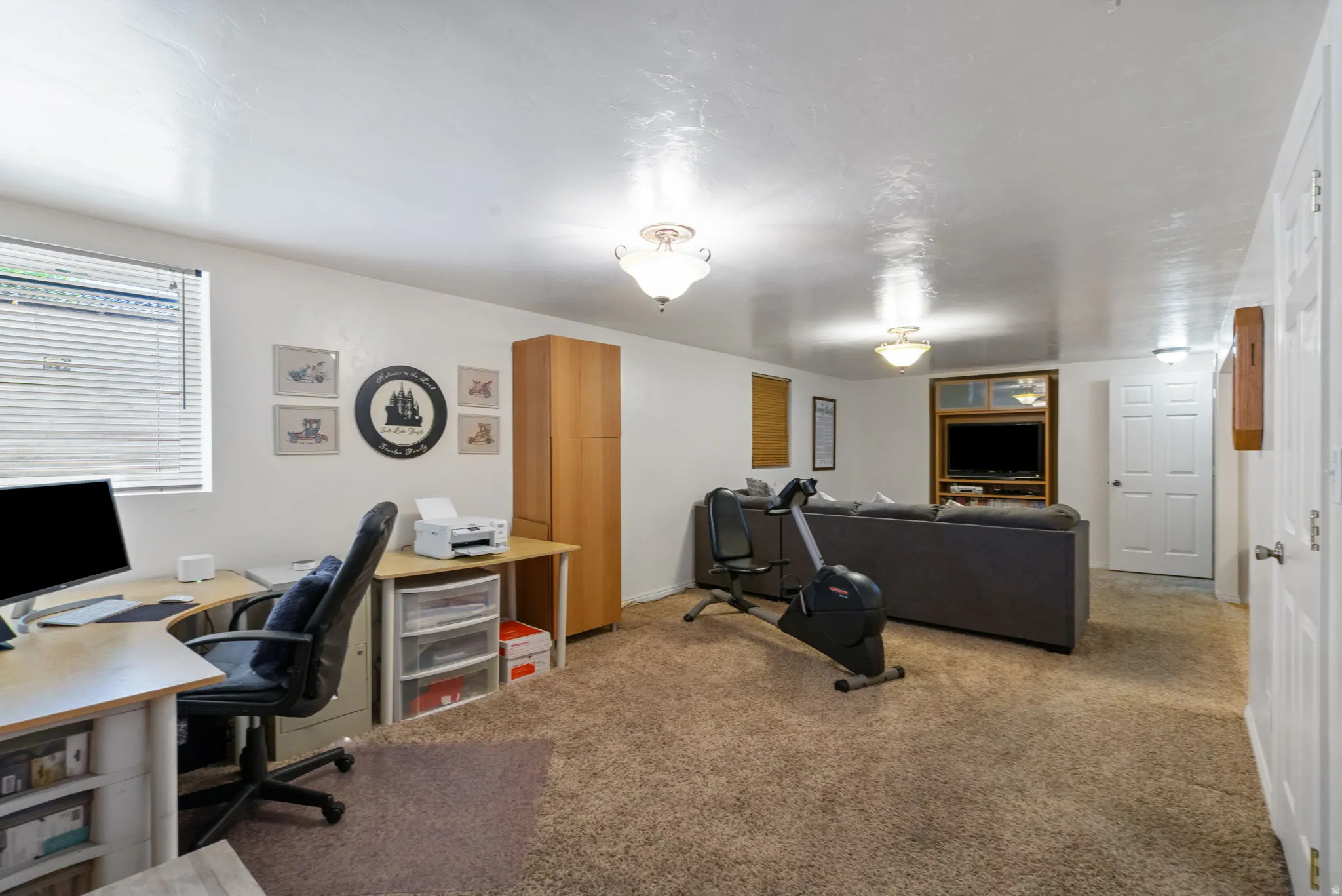 Carpeted room with a built-in media center and window with wood trim