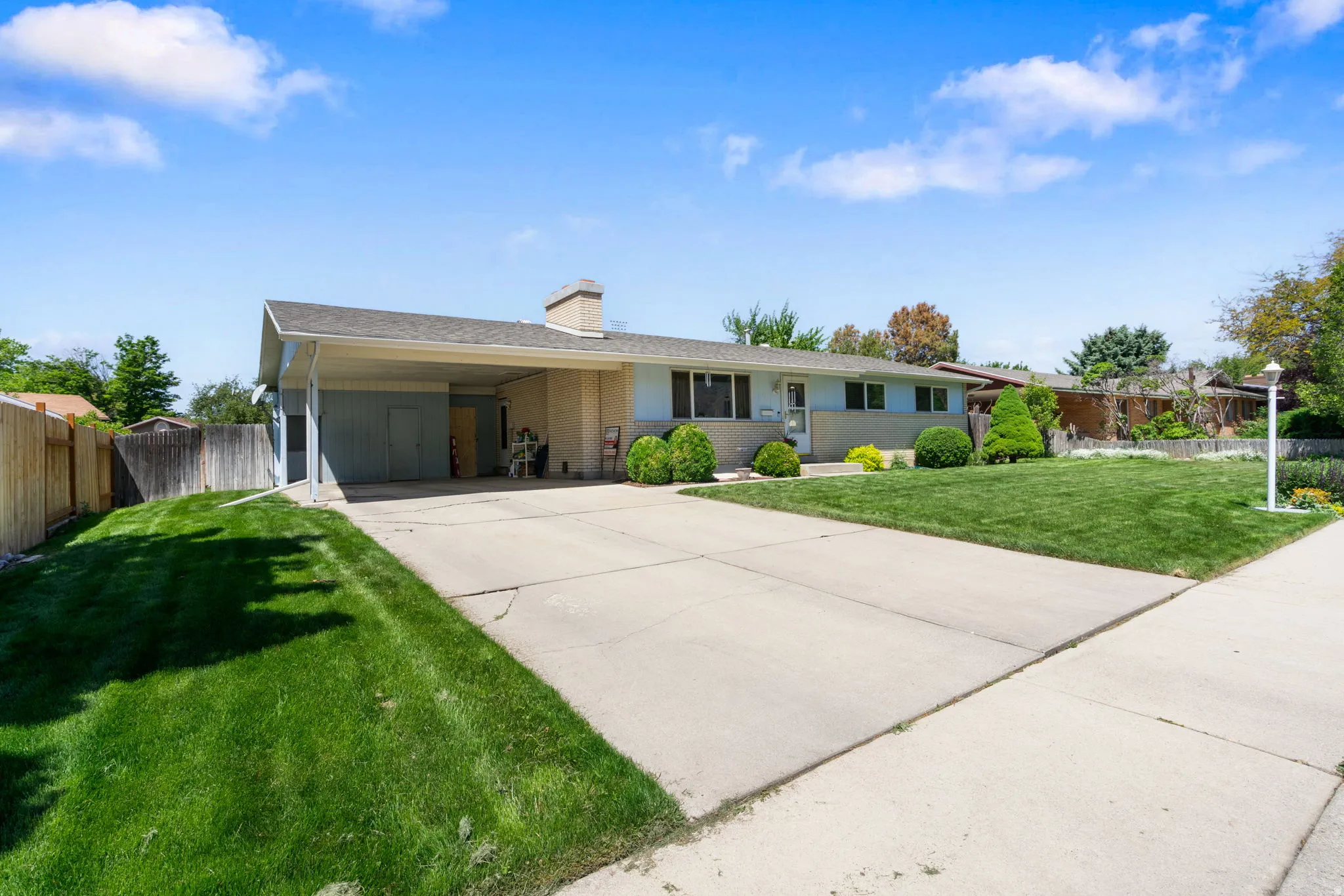 Ranch-style exterior with a carport and an extended concrete driveway